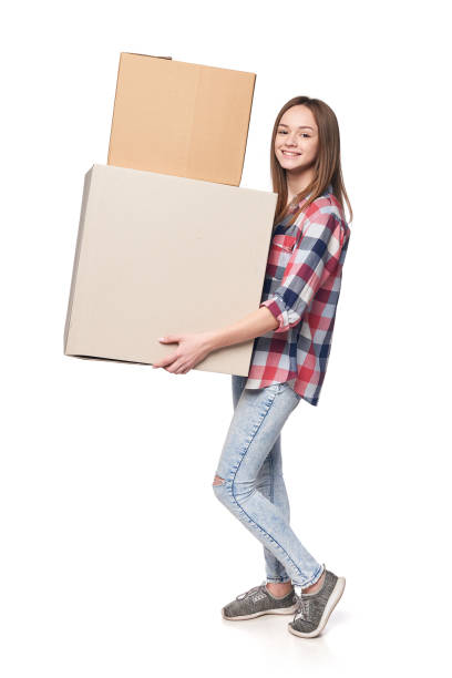 istock Smiling young woman holding cardboard boxes in full length 1135536518