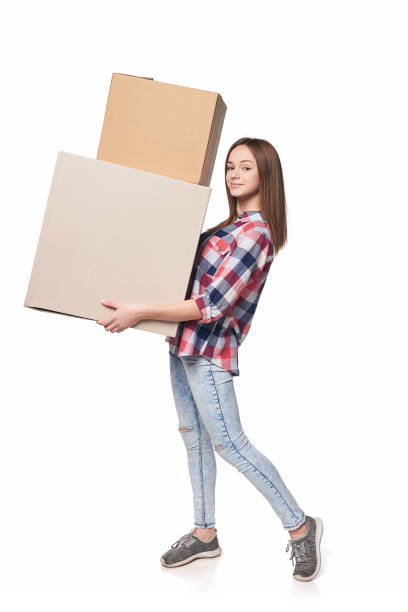 istock Smiling young woman holding cardboard boxes in full length 1135536613