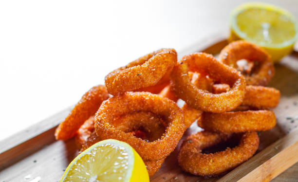 istock fried squid rings breaded with lemon on wooden table background 1135538069