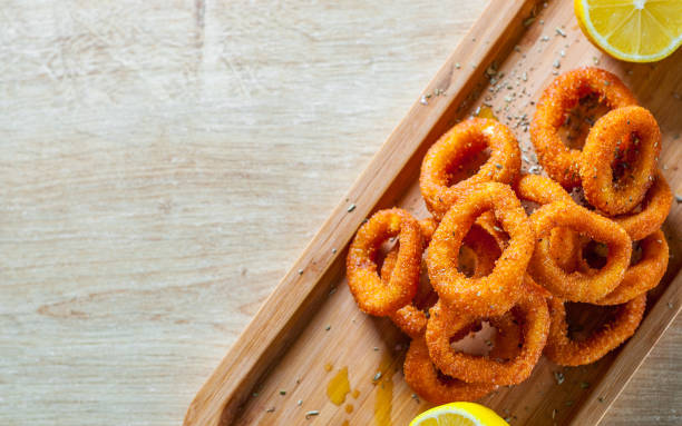 istock fried squid rings breaded with lemon on wooden table background 1135538070