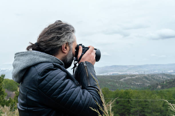 istock Man taking photo with full frame camera from up on the hill 1135538071