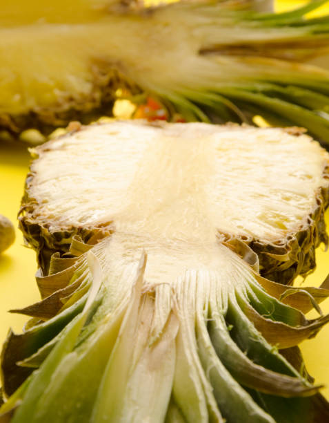 istock Half of juicy fresh pineapple on yellow bacground 1135543109