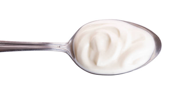 istock Sour cream in metal spoon isolated on white background. Top view. Flat lay 1135544041
