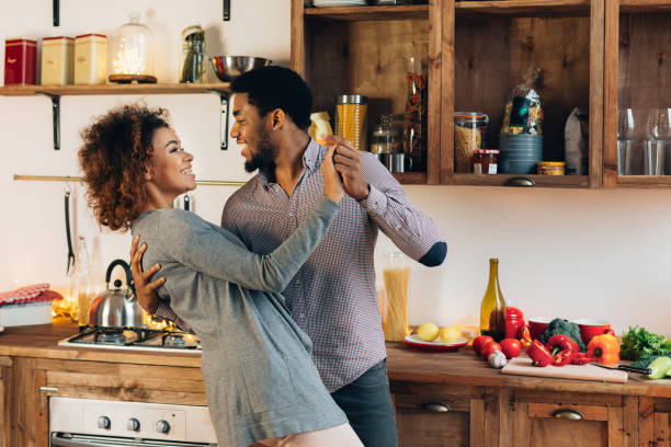 jeune couple afro-américain dansant dans la cuisine, espace de copie - grands évènements de la vie photos et images de collection