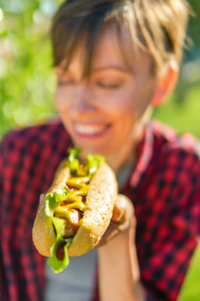 istock Young caucasian woman eating  hot dog 1135548006