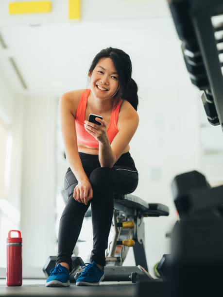 istock Young Asian woman using phone in gym 1135550667