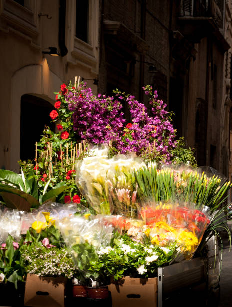 Rome, Italy: A lush truck bed full of bouquets of spring flowers in a city street in early morning.
