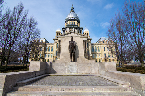Abraham Lincoln statue standing proud in front of the state capitol building in Springfield, Illinois.