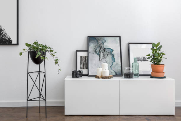 White sideboard and flower stand Home interior with white sideboard, metal flower stand and modern framed prints flower market stock pictures, royalty-free photos & images