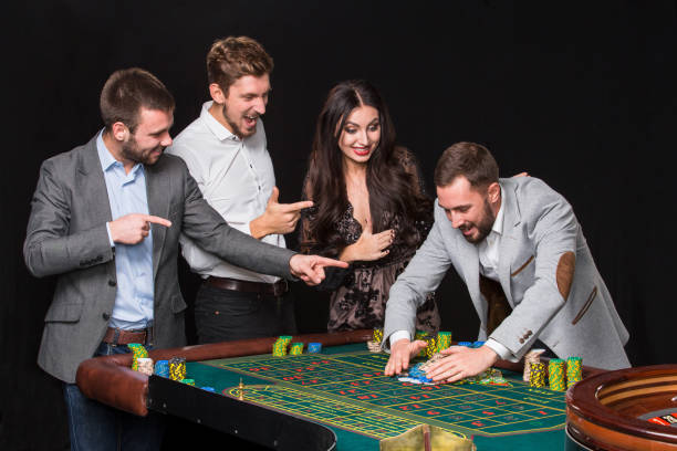 istock Group of young people behind roulette table 1135554068