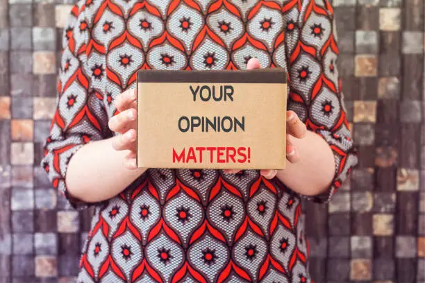 Photo of Word writing text Your Opinion Matters on cardboard holding by woman