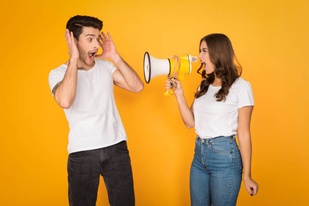 istock Angry woman shouting at man with loudspeaker 1135555433