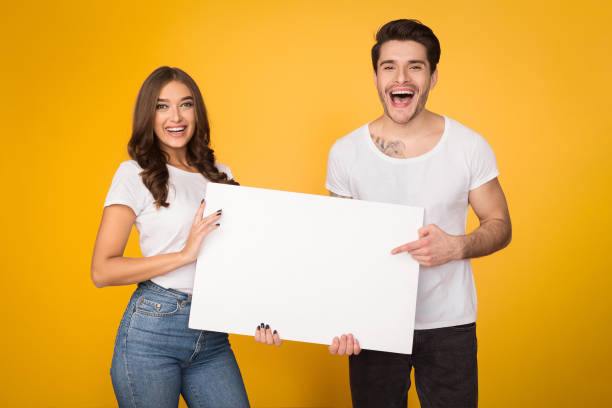 istock Happy couple holding white banner with copy space 1135555452
