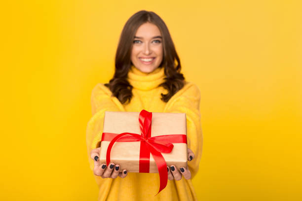 istock Happy woman stretching gift box over background 1135555474