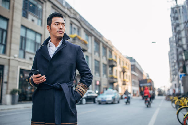 Businessman standing on the city streets and using phone