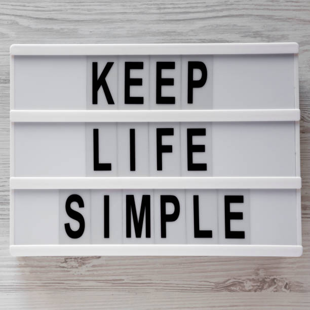 istock Modern board with text 'Keep life simple' over white wooden surface, top view. Flat lay, from above. 1135556940