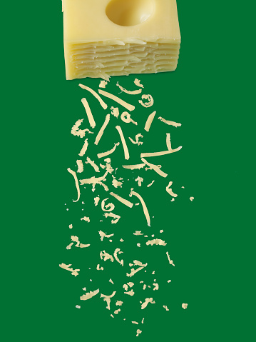 Cheese sprinkles on green background with clipping path