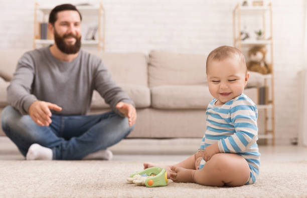 istock Father playing with his baby son on floor at home 1135558849