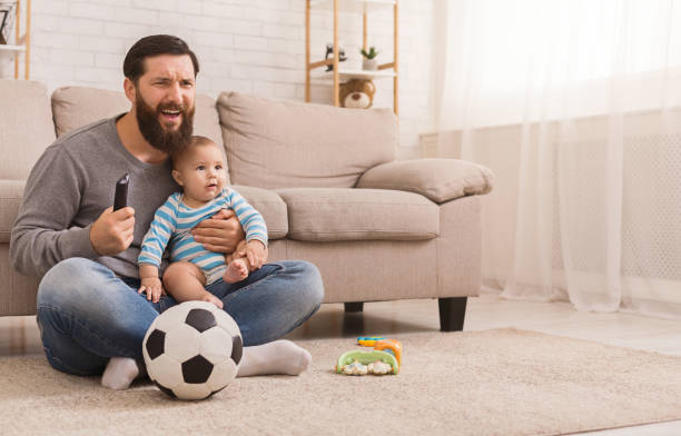 Dad and his son watching football at home