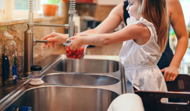 istock Working in the kitchen, mother and daughter washing vegetables 1135559654