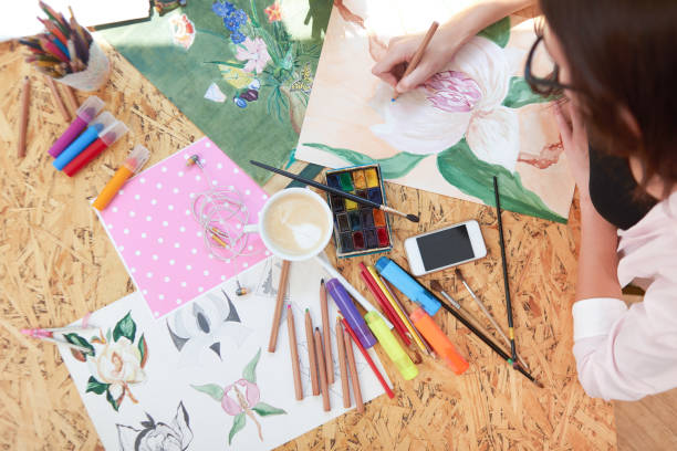 istock Painter drawing picture of beautiful flower. 1135560157