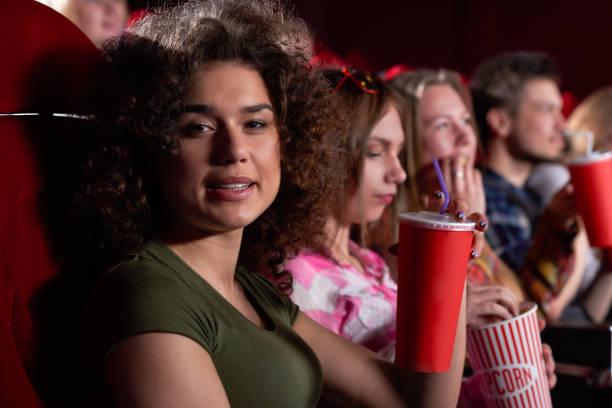 istock Happy brunette sitting in cinema hall. 1135560263