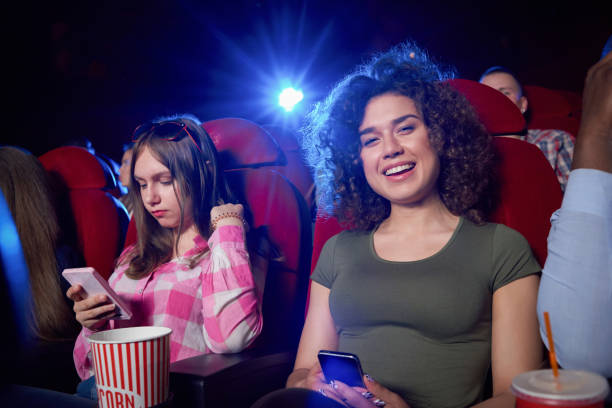 istock Brunette smiling and posing during film in cinema. 1135560272