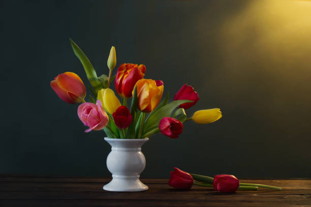 istock beautiful tulips in vase on green background 1135562989