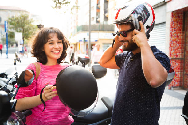 istock Young couple putting on helmet to ride a motorcycle 1135564408