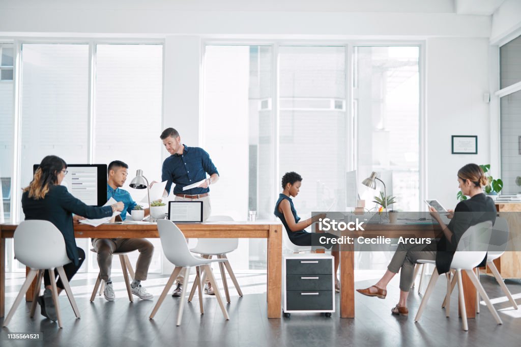 Handling business like the go getters they are Shot of a team of businesspeople working together in a modern office Office Stock Photo