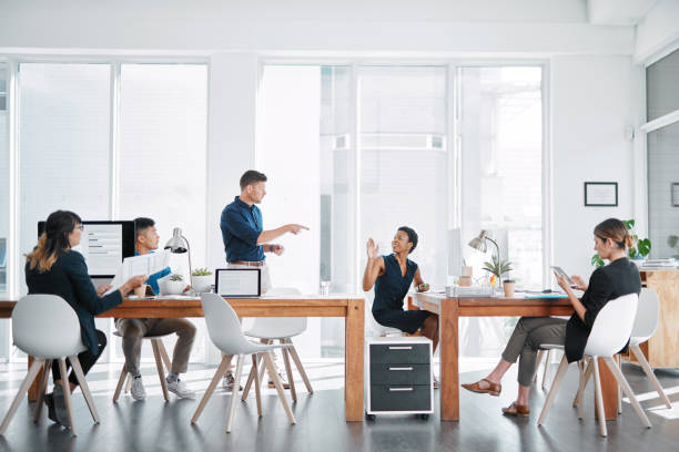 Who's in charge of this task? Shot of a team of businesspeople working together in a modern office delegating stock pictures, royalty-free photos & images