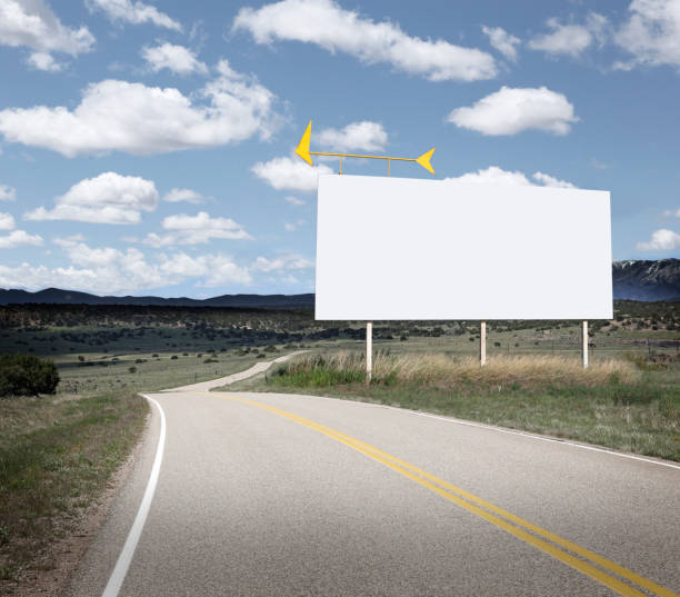 o quadro de avisos em branco está ao longo de uma estrada rural do enrolamento - outdoor road - fotografias e filmes do acervo