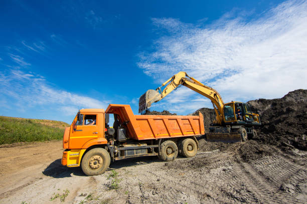 istock Earth mover plunges raw materials into a dump truck 1135565268