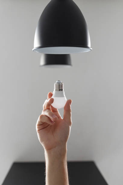 istock Changing the bulb for led bulb in floor lamp in black colour. On light gray background 1135566444