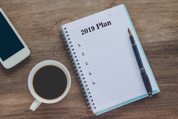istock 2019 Plan text on book note with cup of coffee, pen and smartphone. 1135566595