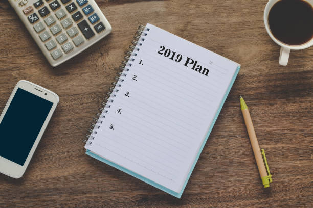istock 2019 Plan text on book note with cup of coffee, pen and smartphone. 1135566608