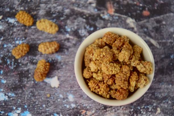 istock Dried mulberry in a bowl over grey background 1135567494