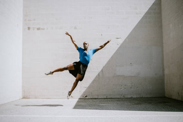 Male Ballet Dancer At Los Angeles Park A graceful African American man dances ballet outdoors on a warm California day, performing various movements, jumps, and leaps. ballerina shadow stock pictures, royalty-free photos & images