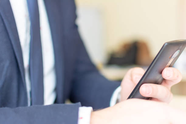 istock Man sitting while using the mobile smartphone. Confident Entrepreneur working on phone. 1135571962
