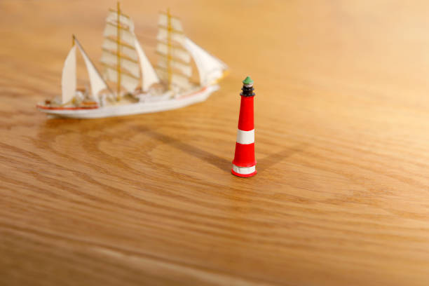 A simple composition of a stack of books and lighthouse with copy space on black background