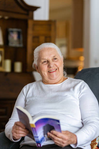 istock Old lady reading a book indoors 1135574991