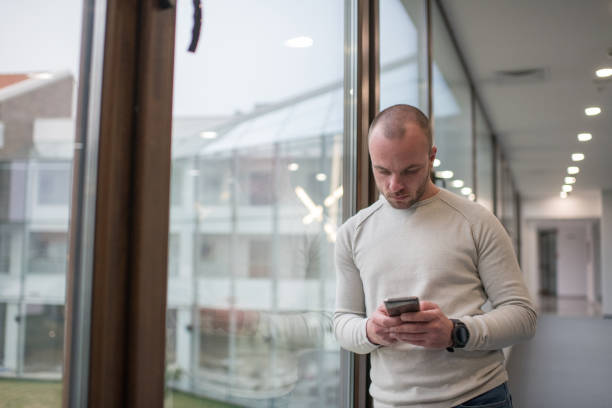 istock Handsome businessman texting outside of his office 1135575681