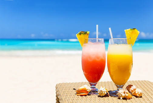 Two tropical fresh juices on white sandy beach in Punta Cana, Dominican Republic