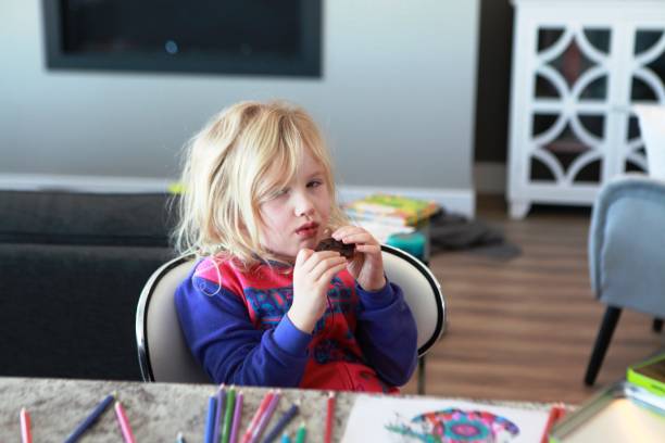 istock Young girleating a cookie at snack time 1135579832