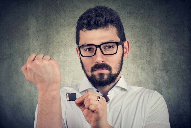 istock Young man holding a microchip willing to implant it under the skin 1135580183