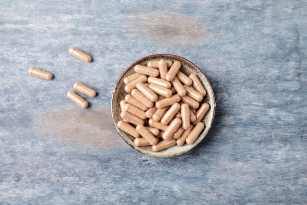 istock Cat's Claw (Uncaria tomentosa)  Extract Capsules. A Dietary Supplement. Immune System Support. Rustic wooden background. Directly Above. Copy space. 1135581350