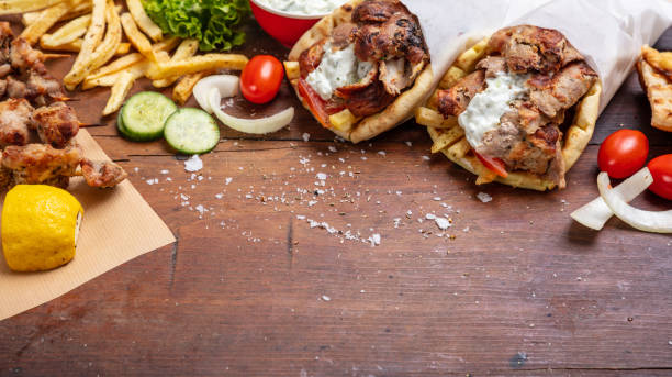 gyro pita, shawarma, souvlaki. two pita bread wraps and meat skewers on wooden table - opa! souvlaki of greece imagens e fotografias de stock