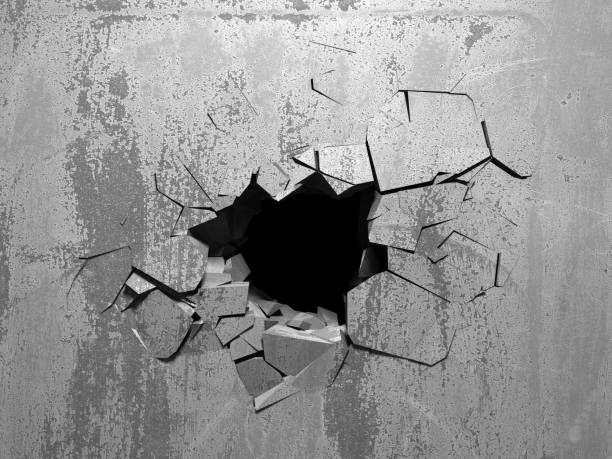 istock Dark cracked broken hole in concrete wall 1135586686