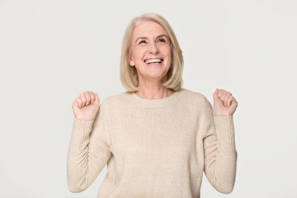istock Happy overjoyed middle aged woman celebrating win isolated on background 1135587085