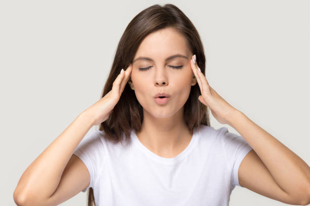 menina adolescente forçada que acalma-se para baixo massagear templos isolados no fundo - inhaling breathing exercise one person relaxation - fotografias e filmes do acervo